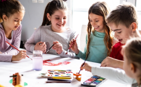 5 Kinder malen zusammen an einem Bild