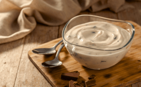 Stracciatella Gericht mit zwei Löffeln auf einem Holzbrettchen
