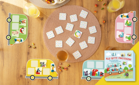 Draufsicht auf ein Kinderspiel mit Tiermotiven namens "Alle Bitte Einsteigen!", bestehend aus vier Bus-Spielbrettern und quadratischen Karten, auf einem Holztisch mit Süßigkeiten und Getränken.