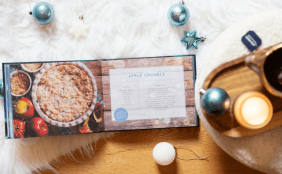 Aufgeschlagenes Buch "Das Geheimnis von Asfjördur" in weihnachtlichem Ambiente passend zum Buch