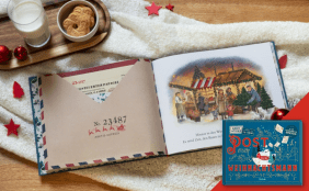 Aufgeschlagenes Kinderbuch "Post vom Weihnachtsmann". Die linke Seite zeigt einen Briefumschlag des "Arktis-Express" und die rechte Seite eine Illustration eines Weihnachtsmarktes. Das Buch liegt auf einem Strickplaid neben Keksen und Milch.
