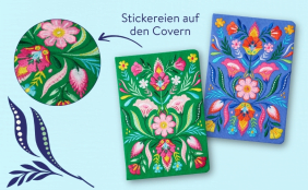 Zwei Notizbücher mit aufwendigen, farbenfrohen Stickereien auf Stoffcovern. Eines ist in kräftigem Grün, das andere in hellem Blau gehalten; beide zeigen symmetrische florale Motive. Eine Lupen-Ansicht hebt die feine Textur der Bestickung hervor.