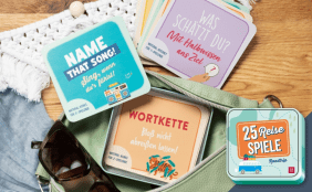 Das Bild zeigt eine geöffnete, mintfarbene Gürteltasche, aus der eine Sonnenbrille sowie eine Schachtel mit Karten herausschaut. Die Karten zeigen das Spiel "25 Reisespiele Roadtrip". Das Cover dazu ist unten rechts in der Ecke abgebildet.