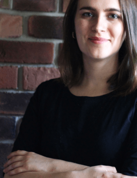 Katharina Hoppe im Porträt mit verschränkten Augen in die Kamera blickend