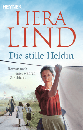 Buchcover des Romans "Die stille Heldin" von Hera Lind, das eine Frau zeigt, die mit ernstem Blick Wäsche aufhängt, während im Hintergrund ein Mann und zwei Kinder auf einem Feldweg in einer ländlichen Idylle gehen.