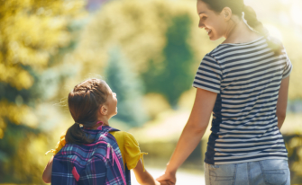Mutter und Tochter laufen Hand in Hand in Richtung Grünfläche
