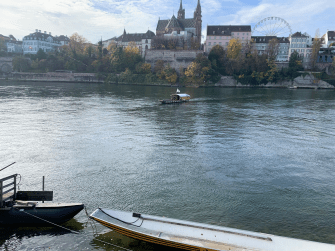 Der Rhein in Basel. Das Bild zeigt einen Ausschnitt des Rheins. Im Hintergrund ist ein Stück Basels abgebildet.