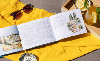 Innenseite aufgeklappt auf gelbem Tuch, Sonnebrille und sommerlichen Getränk