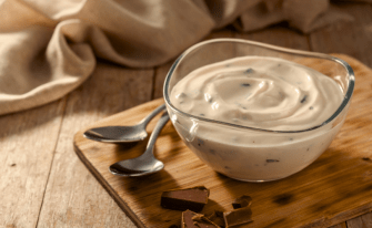 Stracciatella Gericht mit zwei Löffeln auf einem Holzbrettchen