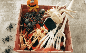 Halloween Box gefüllt mit Skeletthänden, Spinnen und weiterer Halloween-Deko