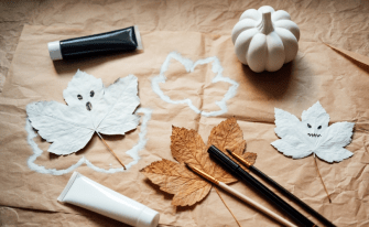 Herbstblätter angemalt als kleine Geister mit bösen Gesichtern