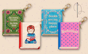 4 verschiedene bestickte Täschchen mit Motiven und Sprüchen rund um das Thema "Bücherliebe", eine Sticknadel verweist nochmals auf den bestickten Charakter der Täschchen