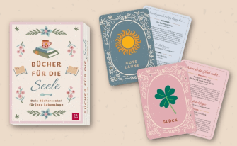 Das Kartenset „Bücher für die Seele – Dein Bücherorakel für jede Lebenslage“. Neben der hellen Box mit Blumen- und Buchmotiven sind Orakelkarten ausgelegt, die passende Buchtipps (z. B. Der Buchspazierer oder Hectors Reise) für verschiedene emotionale Zustände wie „Glück“ oder „Gute Laune“ bereithalten.