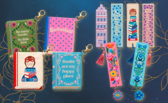 Verschiedene bestickte Accessoires für Buchliebhaber auf dunkelblauem Hintergrund. Links sind vier kleine Reißverschlusstäschchen in Buchform mit Schlüsselanhängern zu sehen (u. a. mit den Aufschriften „Buchverliebt“ und „Books are my happy place“). Rechts daneben liegen sechs farbenfroh bestickte Stoff-Lesezeichen mit anhängenden Quasten und Blumen-Anhängern.