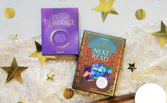 Zwei Kartensets 'Let’s Talk Romance' und 'My Next Read' auf glitzerndem Stoff mit goldenen Dekosternen.
