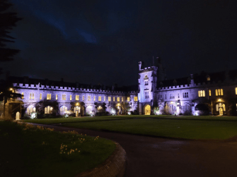 Sclossähnliches Gebäude des University College Cork bei nacht beleuchtet
