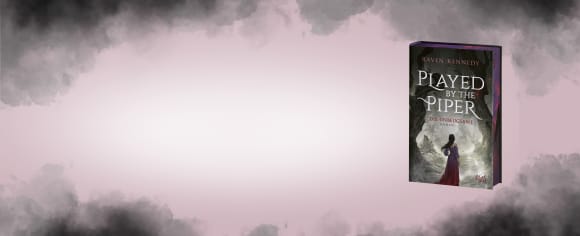 Das Buch „Played by the Piper – Die Unbeugsame“ von Raven Kennedy mit verziertem Farbschnitt vor einem zartrosa Hintergrund, der von dunklen Rauchwolken eingerahmt wird.