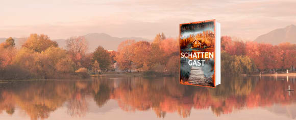 Ein Werbebanner für den Kriminalroman „Schattengast“ von Malin Stehn, dessen Buchcover vor dem Hintergrund einer herbstlichen Park- oder Seenlandschaft mit bunt gefärbten Bäumen, Bergen im Hintergrund und einer Spiegelung im ruhigen Wasser platziert ist.