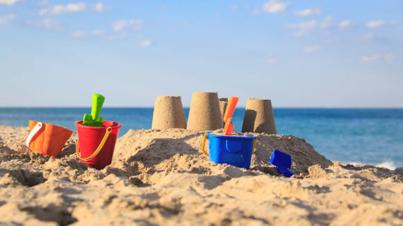 Sandburg am Meer mit Schaufel und Zubehör