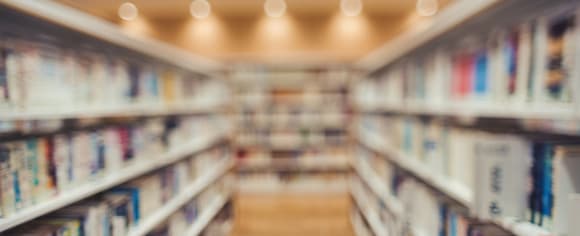 Gang mit Bücherregalen und Beleuchtung von oben.