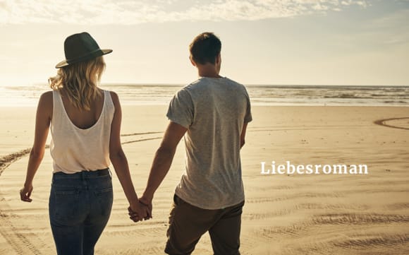 Ein Paar läuft Hand in Hand am Strand entlang