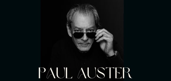 Foto von Paul Auster, er schaut über den Rand einer Sonnenbrille