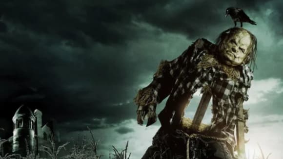 A creepy scarcrow in front of dark clouds and a spooky house. A Crow sits on it's head