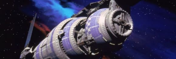 Die Raumstation Babylon 5. Sieht wie eine längliche Röhre aus, die aus einzelnen kleinen runden Turbinen besteht.