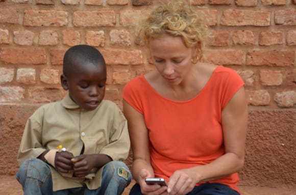 Katja Riemann zeigt einem kleinen Jungen ihr Smartphone