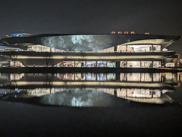 Das Science-Fiction-Museum, in dem der Worldcon stattfand. Ein futuristisches Gebäude mit viel Glas und geschwungenen Linien, bei Nacht beleuchtet, das sich in einem See spiegelt.