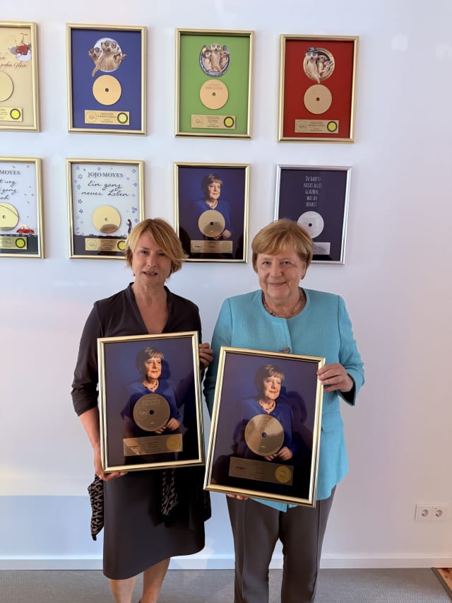 Corinna Harfouch, die das Hörbuch eingelesen hat, und Angela Merkel freuen sich über die Goldene Schallplatte