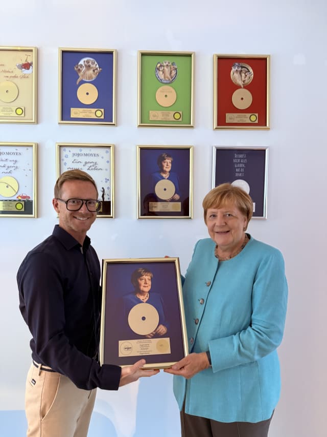 Geschäftsführer von argon, Frederik Wehmeier, überreicht Angela Merkel die Auszeichnung.