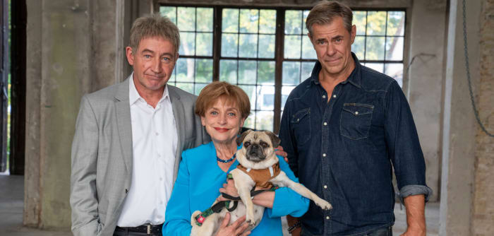 Miss Merkel im Gruppenfoto mit Ehemann Achim, dem Bestatter Kurt Kunkel und Mops Helmut