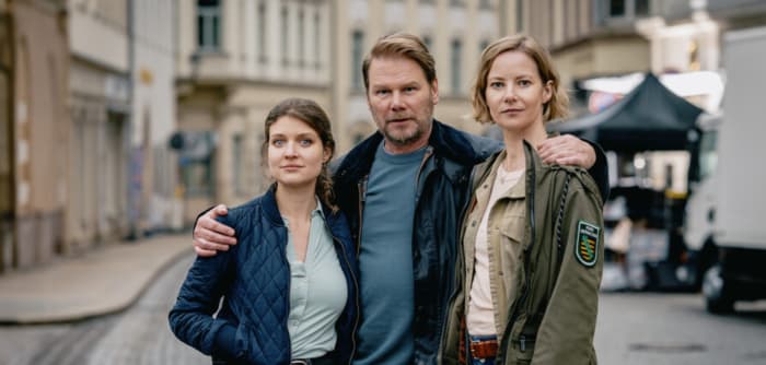 Die drei Hauptdarsteller:innen am Set