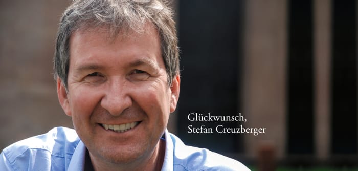 Portrait von Stefan Creuzberger mit weißer Schrift "Glückwunsch, Stefan Creuzberger"