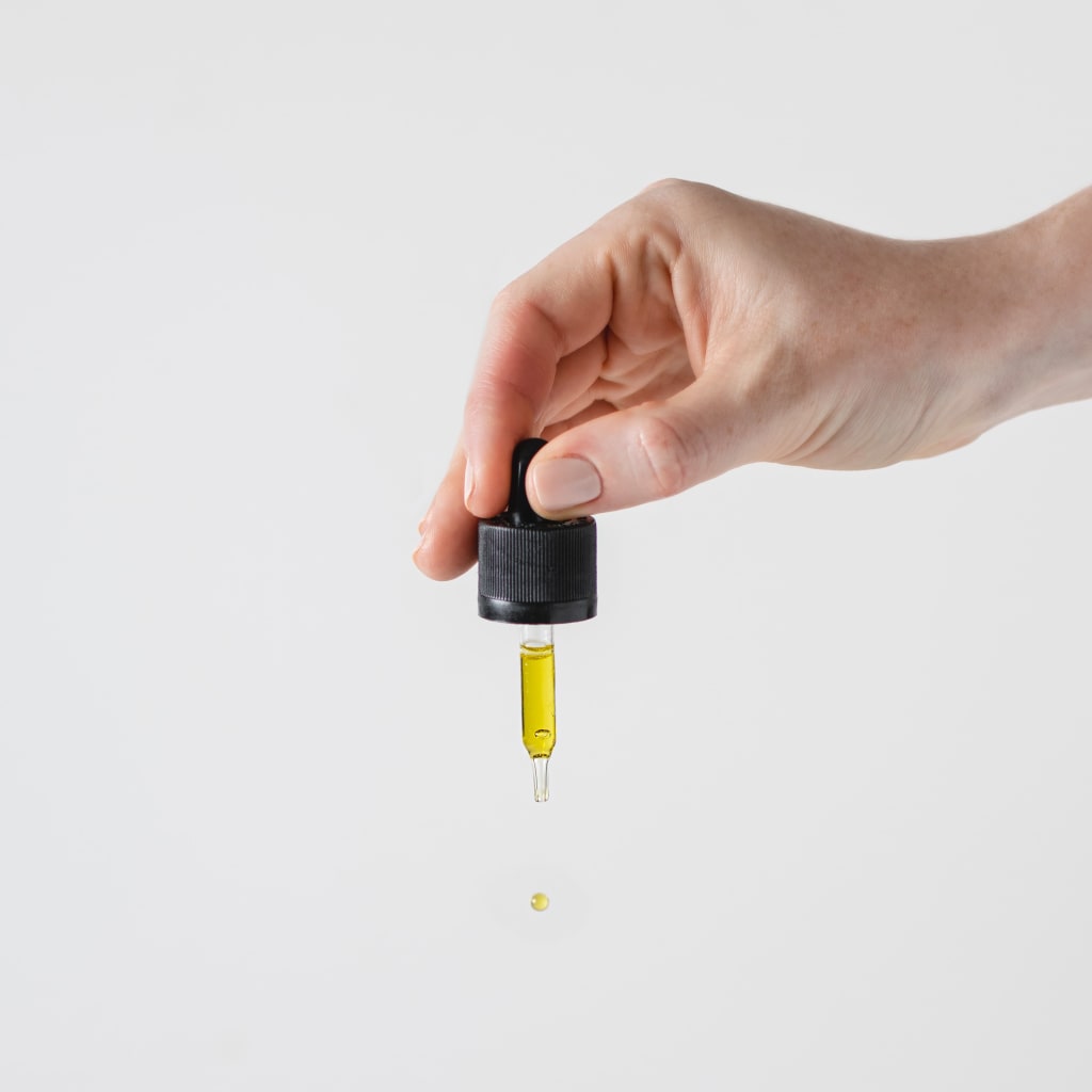 A dropper with CBD oil in it.