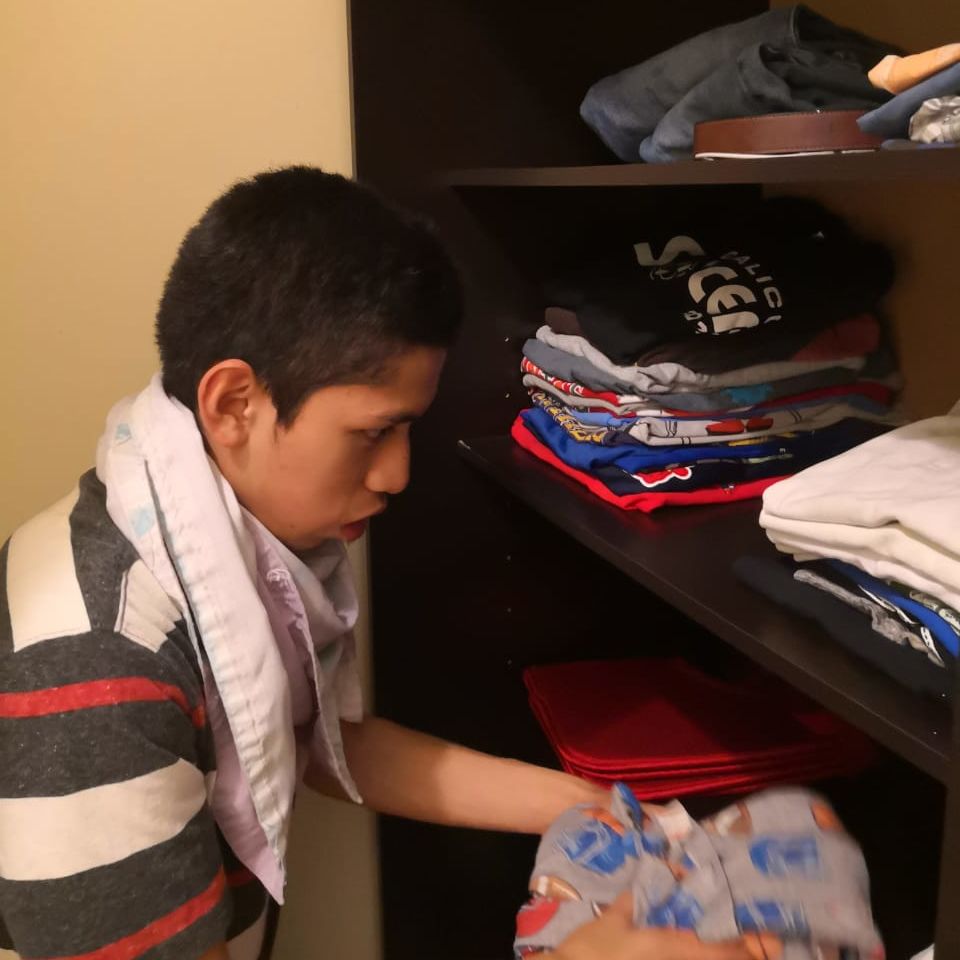 Carlos putting away clothes