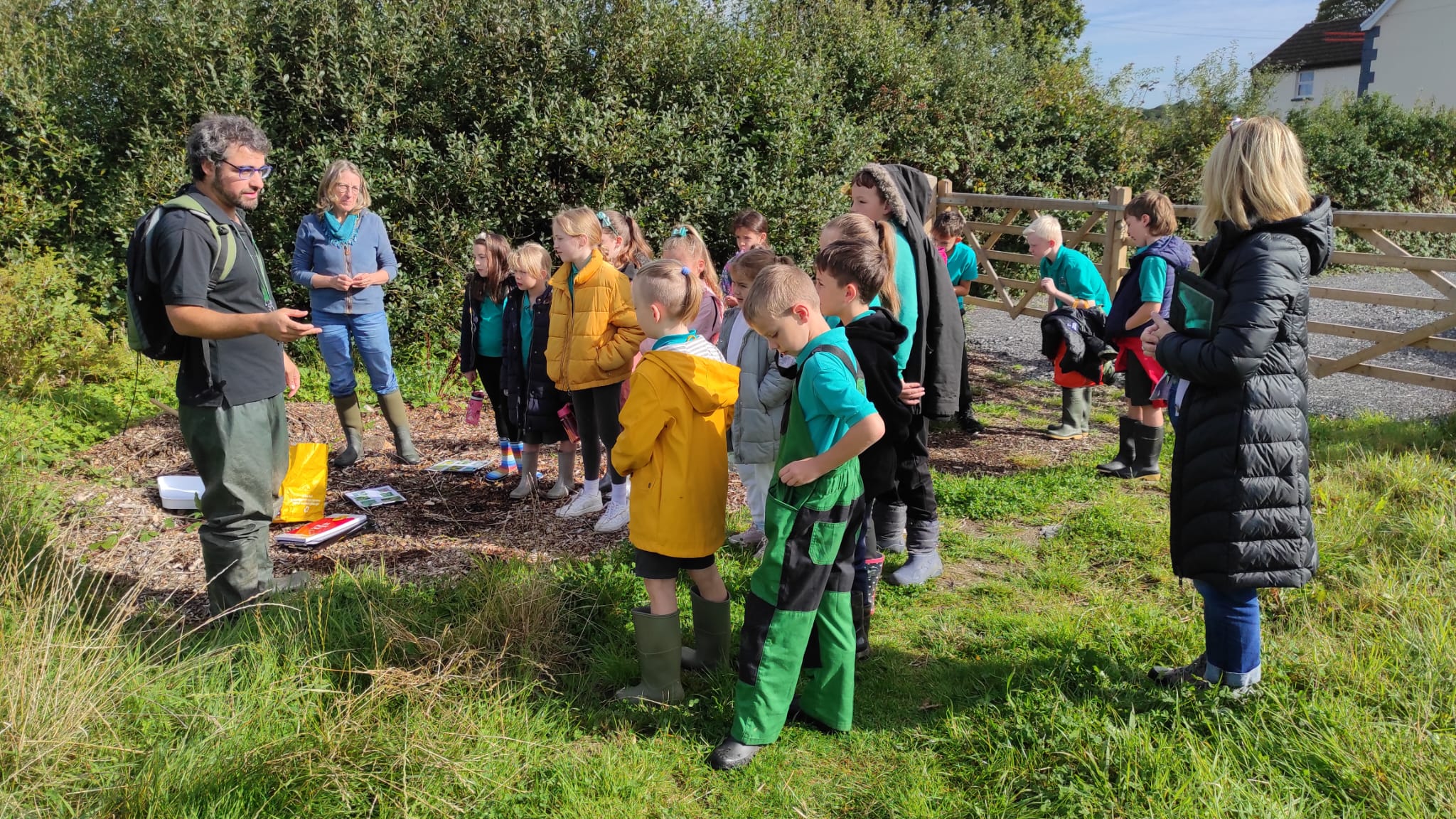 School children gathered around ecologist