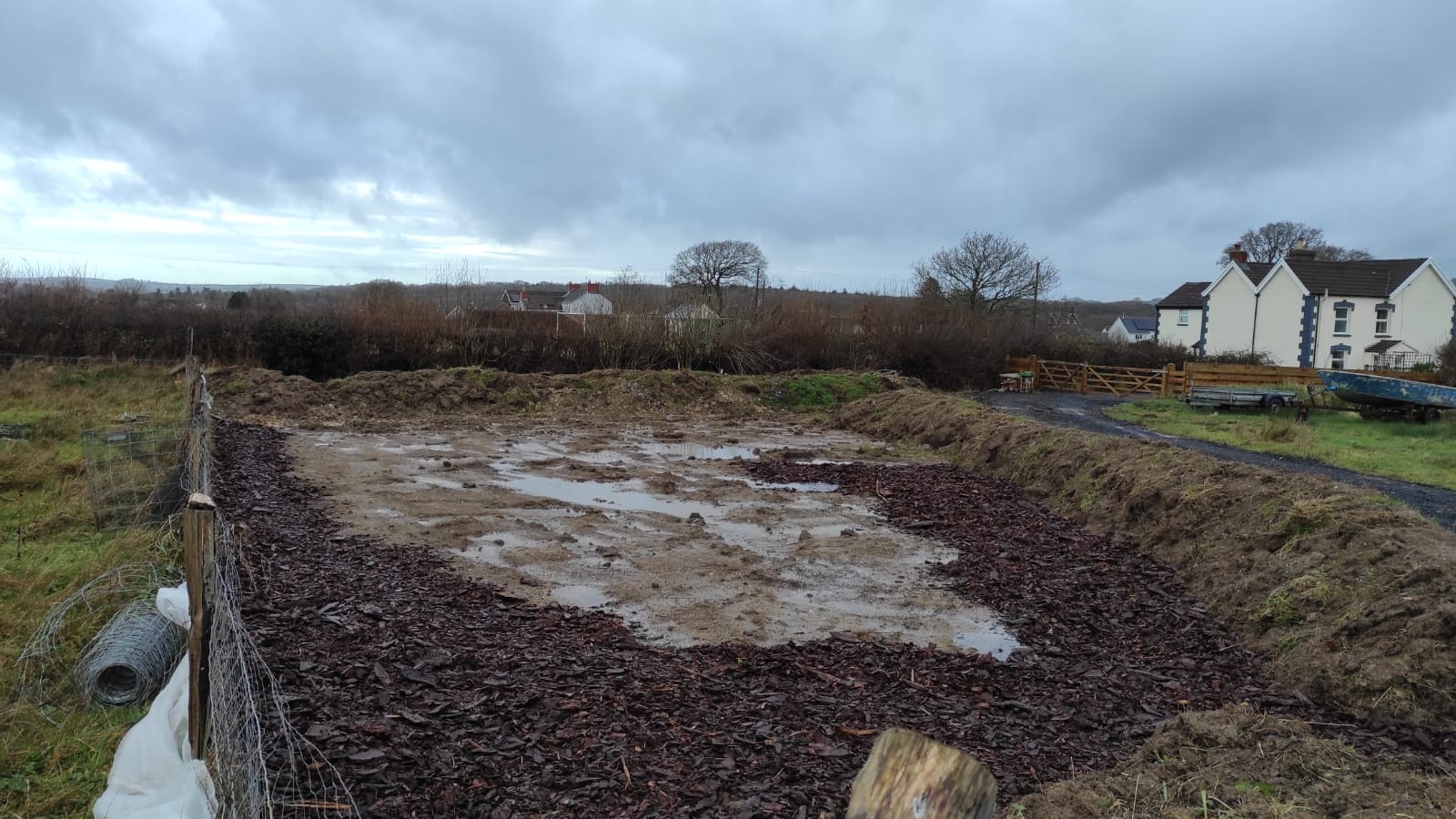 Golygfa o’r ardd hanner y ffordd drwy osod tomwellt
