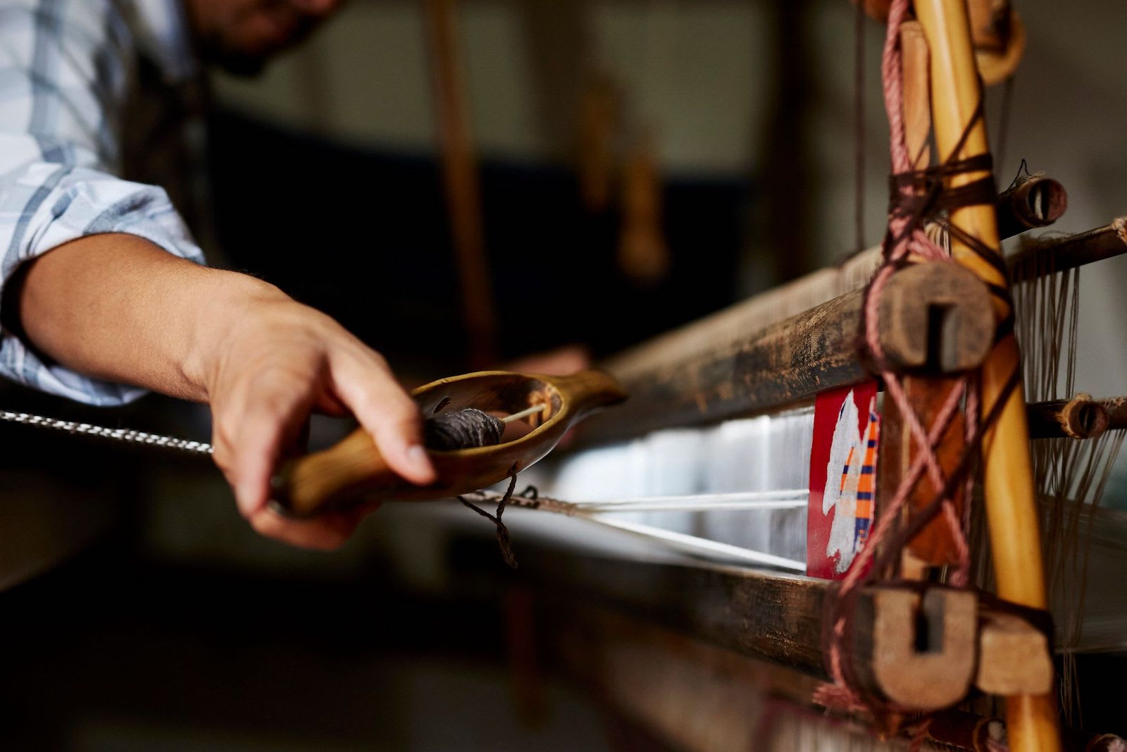 An artisan weaving on a loom