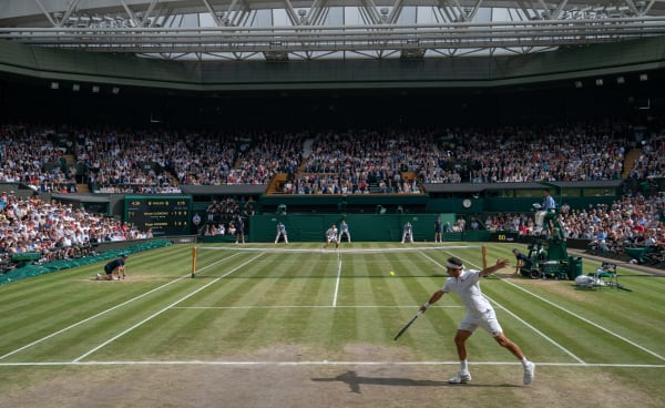 Two tennis players mid-match at Wimbledon.