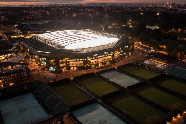 View of Wimbledon from overhead at night time with the roof on and lights turned on.