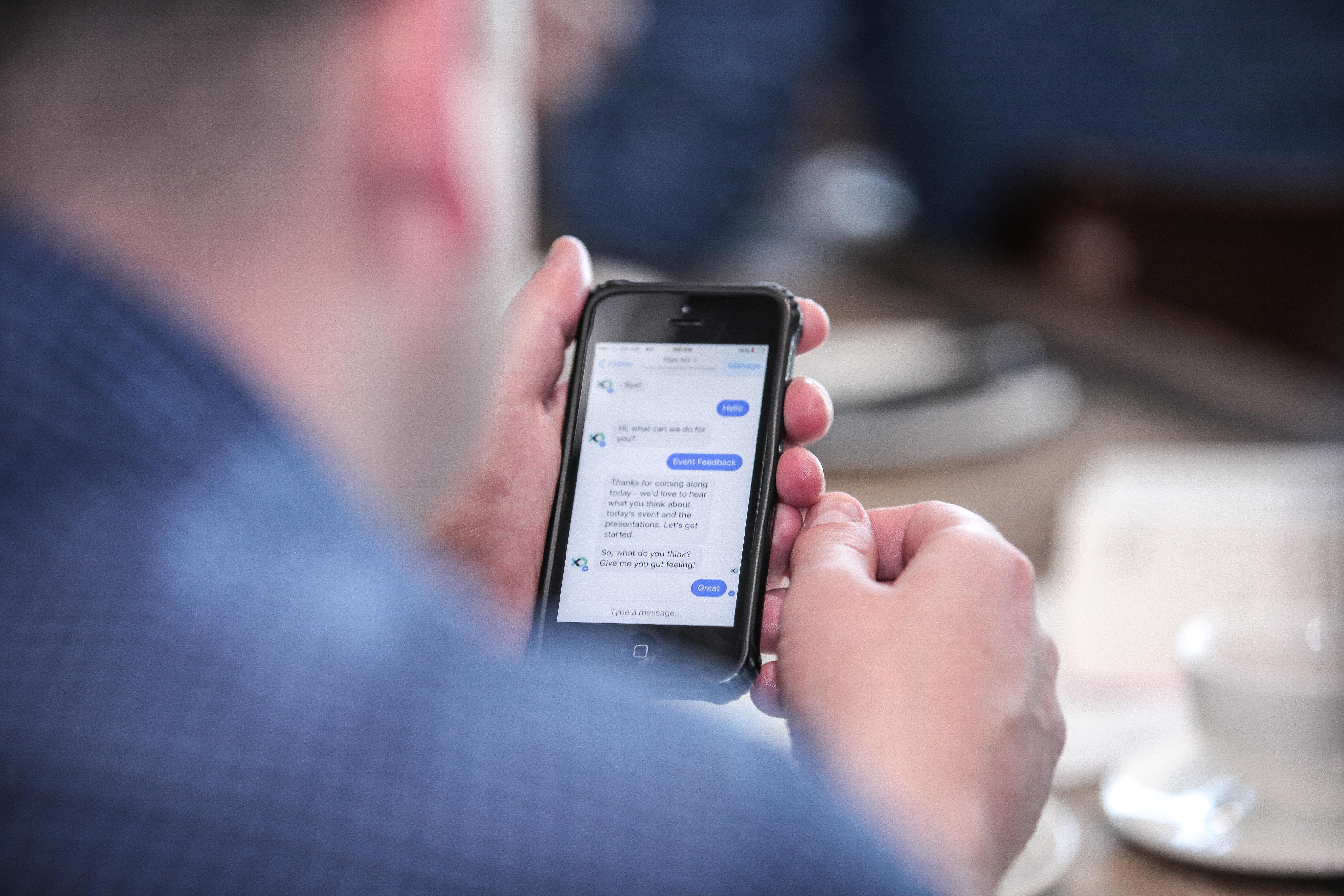 Man Using Phone with call centre chatbot open Man Using Phone with call centre chatbot open