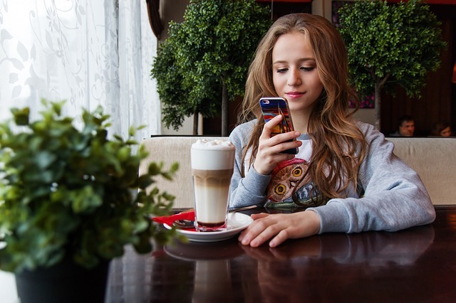 A teen on her phone in a café. A teen on her phone in a café.