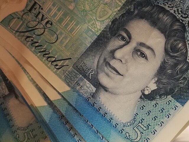 A close-up of five-pound notes. A close-up of five-pound notes.