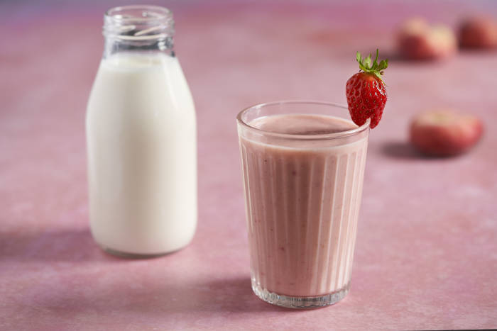 A glass of strawberry and peach kefir smoothie