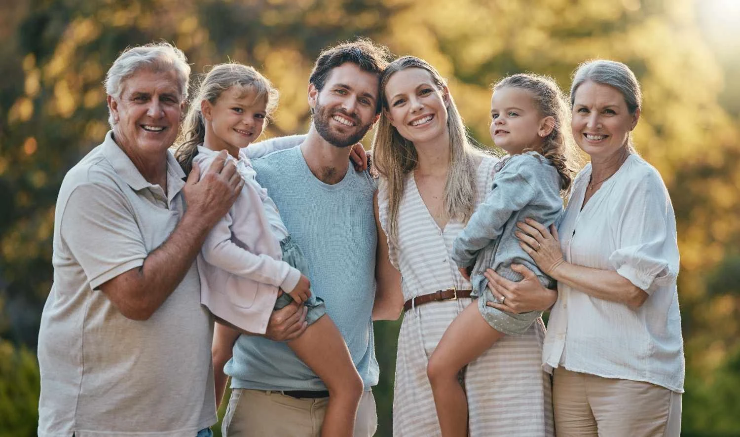 A happy, multi-generational family smiling together in a public park in Frederick, Maryland