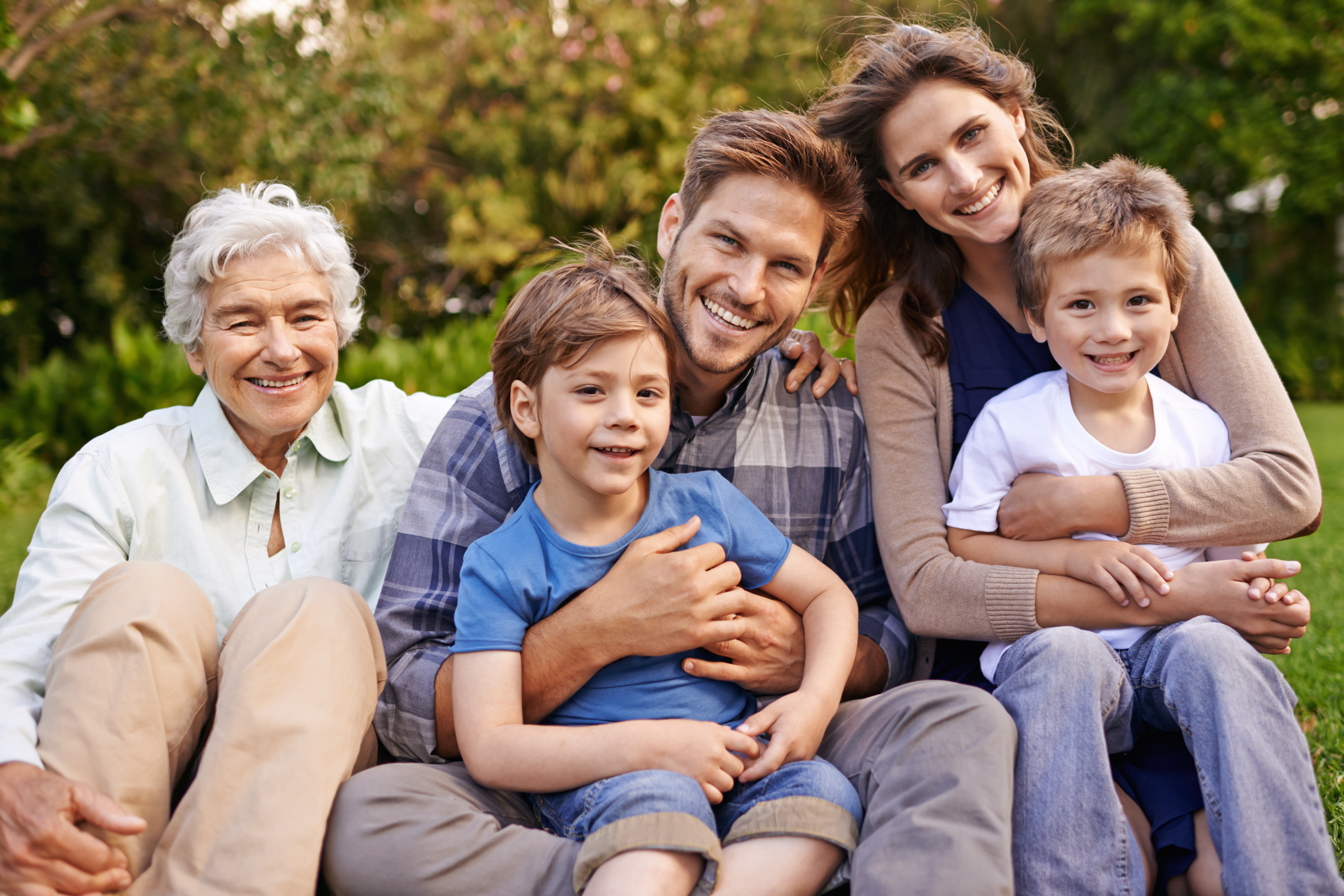A cheerful family portrait of parents and children in a sunny Hopewell, VA community park