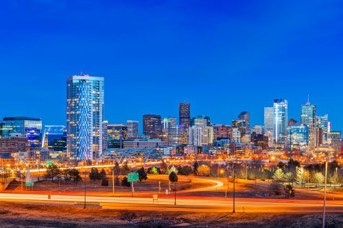 Denver skyline and Rocky Mountain real estate market with housing demand across nearby suburban communities