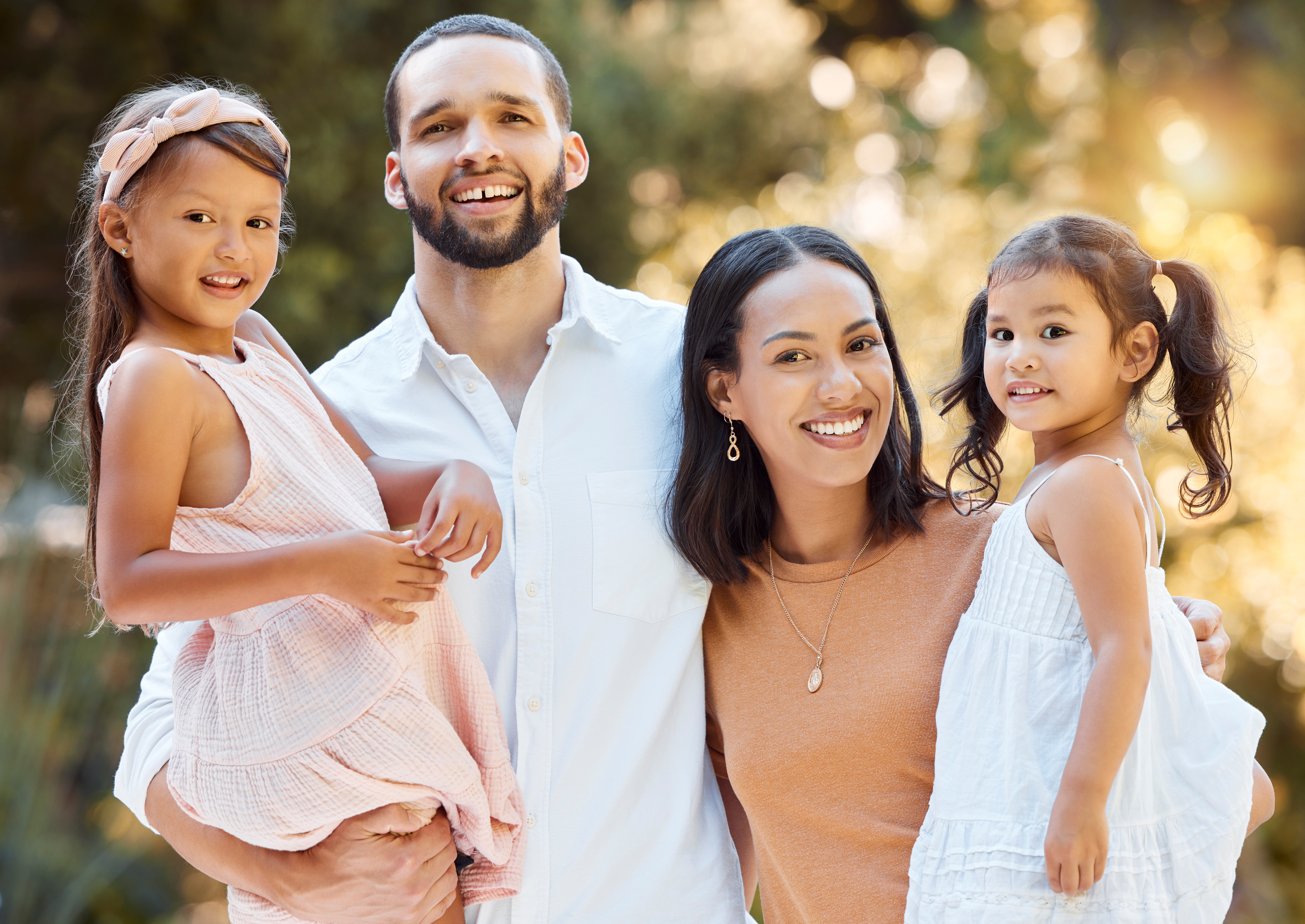 A family portrait of a couple and their children smiling together in a natural park setting in Westminster, MD